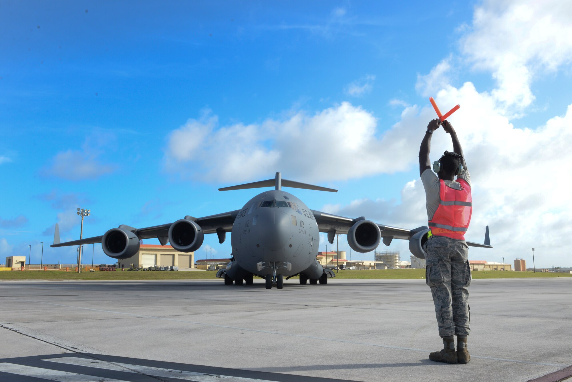 Airman 1st Class David Reed, 734th Air Mobility Squadron crew chief, marshals a C-17 Globemaster III,  April 18, 2015, on the flightline at Andersen Air Force Base, Guam. Airmen from the 36th Wing and the 734th AMS work to project global reach and allow military leaders to employ airpower across the entire spectrum of engagement. (U.S. Air Force photo by Senior Airman Katrina M. Brisbin/Released)