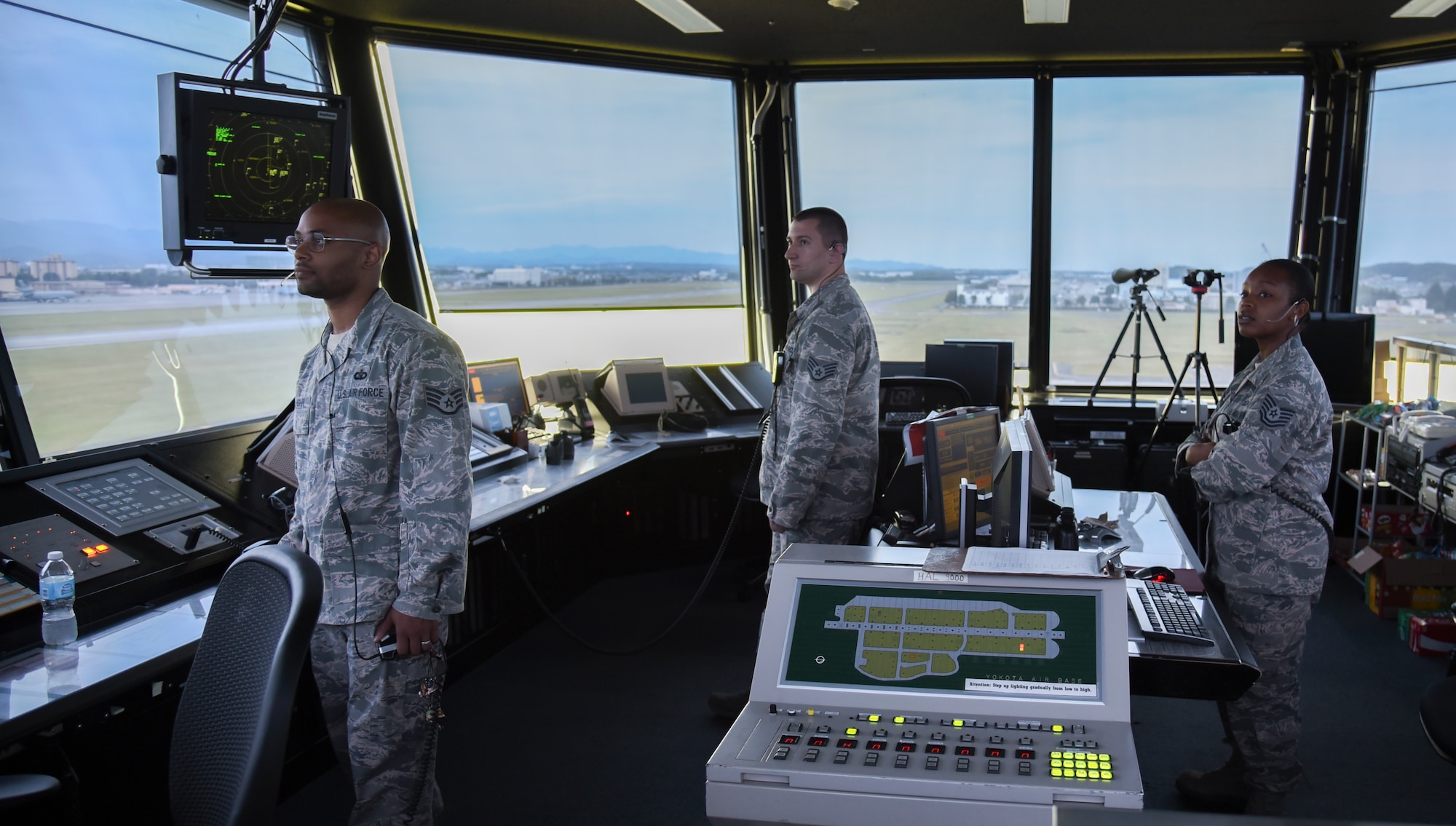 From left to right, Staff Sgts. Randall Vaughn, Johnathan Camp and Tech. Sgt. Charmaine Johnson, 374th Operations Support Squadron watch supervisors, work the tower cab section of the air traffic control tower at Yokota Air Base, Japan, May 8, 2015. The tower cab can handle aircraft within five nautical miles. (U.S. Air Force photo by Senior Airman Michael Washburn/Released)  