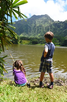 Emelia and Charley Oelrich fish with bamboo fishing poles during the 16th Annual Friends of Hickam Keiki Fishing Tournament  at the Ho`omaluhia Botanical Gardens in Kaneohe, Hawaii, June 5, 2015. The fishing tournament was free for JBPHH Children ages 5-12.(U.S. Air Force photo by Tech. Sgt. Aaron Oelrich/Released)