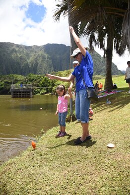 Tech. Sgt. Melissa Paul, 15th Wing command chief executive assistant, and her daughter Kaitlyn catch their first fish of the day at the 16th Annual Friends of Hickam Keiki Fishing Tournament at the Ho`omaluhia Botanical Gardens in Kaneohe, June 5, 2015. Every child walked away from the tournament with a new fishing pole and a fishing story. (U.S. Air Force photo by Tech. Sgt. Aaron Oelrich/Released)