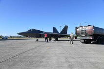 A F-22 Raptor pilot from the 19th Fighter Squadron and maintenance Airmen conduct hot pitting refueling during a sortie surge on Joint Base Pearl Harbor-Hickam, Hawaii, June 6, 2015. In order to fly as many sorties as possible pilots and maintainers conducted hot pit refueling, a procedure performed to rapidly refuel the aircraft and allow it to complete a second sortie in a short amount of time. (U.S. Air Force photo by Tech. Sgt. Aaron Oelrich/Released)   