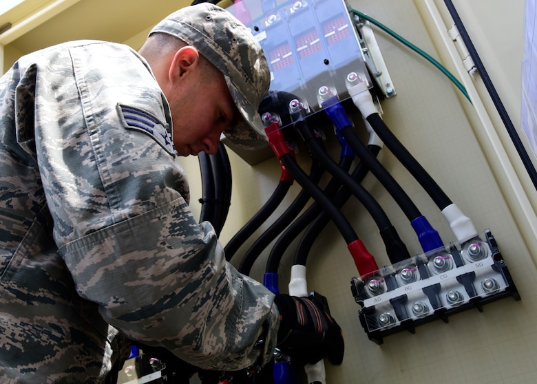U.S. Air Force Senior Airman Andres Diaz Medina, 35th Civil Engineer Squadron electrical systems technician, installs a backup power generator at Misawa Air Base, Japan, June 8, 2015. As an electrician, Diaz Medina installs, services, modifies and repairs specialized electrical systems and equipment. (U.S. Air Force photo by Airman 1st Class Jordyn Fetter/Released)