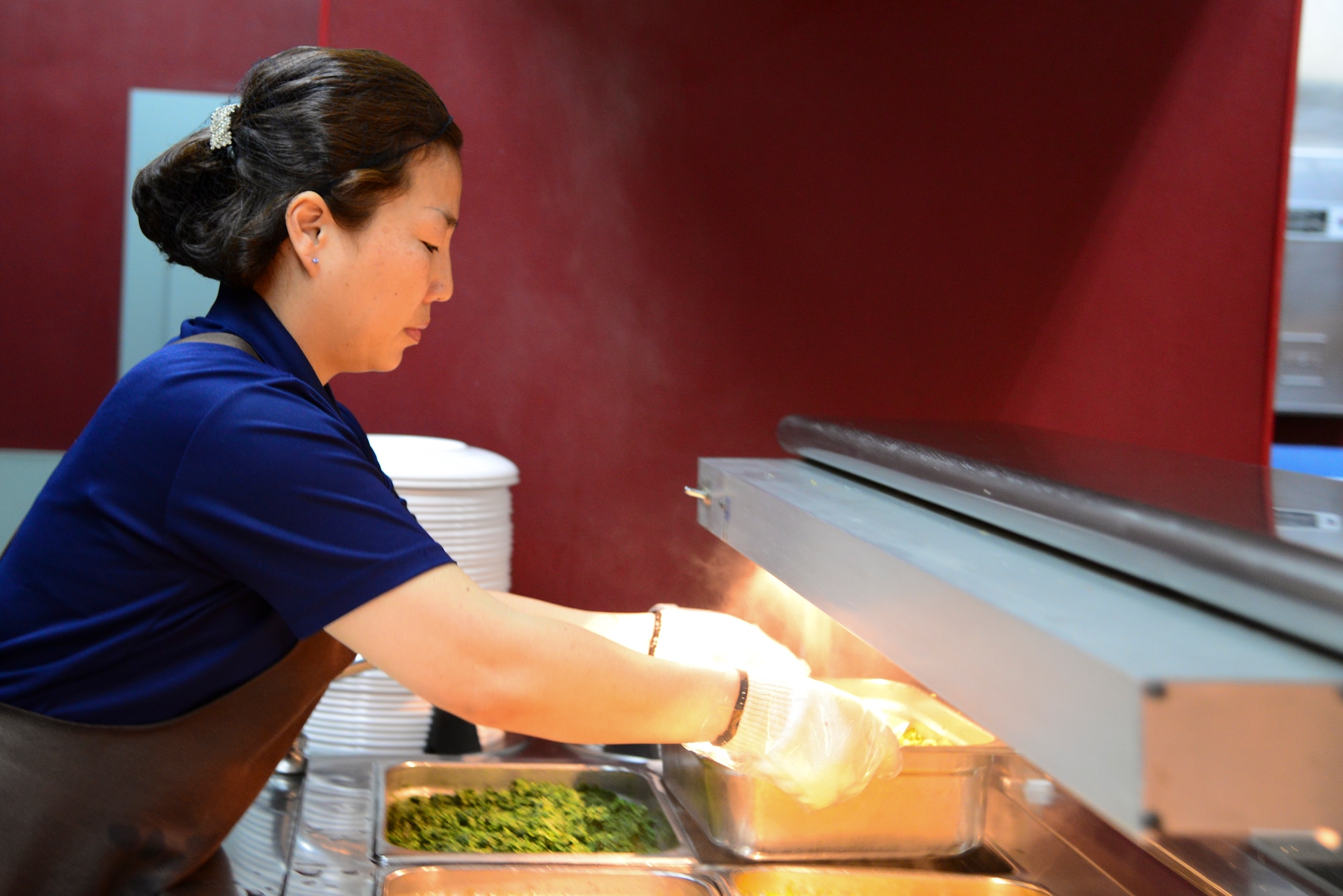 Yi Hyun Chu, Food Attendant Services Gapjin Development Company cashier, sets up the main line for lunch April 1, 2015, at Osan Air Base, Republic of Korea. Each dining facility prepares meals for meal card holders as well as pating customers. (U.S. Air Force photo by Senior Airman Matthew Lancaster)