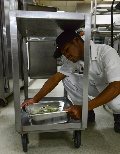 Army Private Sheuoi Bryan, 35th Air Defense Artillery Brigade food service specialist, places food in a warmer April 1, 2015, at Osan Air Base, Republic of Korea. Extra is made to replace food on the line when it runs out. (U.S. Air Force photo by Senior Airman Matthew Lancaster)