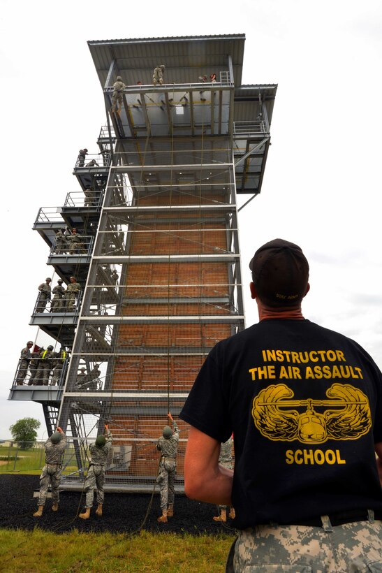 A U.S. Army instructor looks up at the 55-foot tower as students rappel down during an air assault course at the 7th Army Joint Multinational Training Command's Grafenwoehr Training Area, Germany, June 8, 2015. 