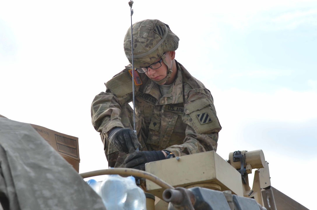 U.s. Army Spc. Kevin Garafano Attaches An Antenna Onto An M1a2 Abrams 