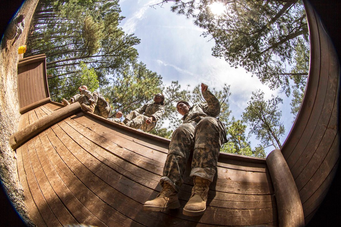 Soldiers jump down into the pit for the final hurdle of the endurance obstacle course during their second week of basic combat training at Fort Jackson, S.C., May 29, 2015. 