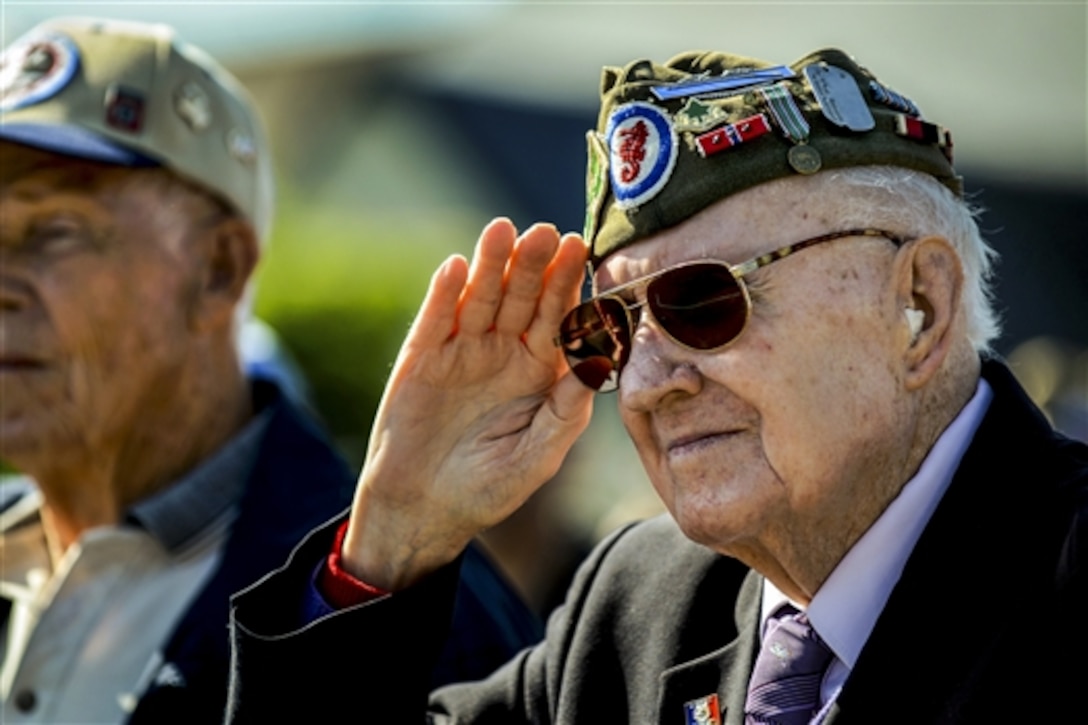 A World War II veteran salutes as "The Star-Spangled Banner" plays during a D-Day ceremony at the 9th Air Force Memorial in Picauville, France, June 4, 2015. 