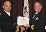 DAHLGREN, Va. (June. 5, 2015) - Capt. Brian Durant, left, Naval Surface Warfare Center Dahlgren Division (NSWCDD) commanding officer, presents the Meritorious Service Medal certificate to Cmdr. Shawn Cowan, NSWCDD senior military deputy for human systems engineering during Cowan's retirement ceremony at the Aegis Training and Readiness Center auditorium