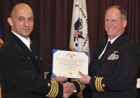 DAHLGREN, Va. (June. 5, 2015) - Capt. Brian Durant, left, Naval Surface Warfare Center Dahlgren Division (NSWCDD) commanding officer, presents the Meritorious Service Medal certificate to Cmdr. Shawn Cowan, NSWCDD senior military deputy for human systems engineering during Cowan's retirement ceremony at the Aegis Training and Readiness Center auditorium