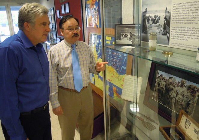 Udo Goff – a Naval Surface Warfare Center Dahlgren Division (NSWCDD) defense contractor and avid collector of World War II artifacts – explains the unique histories behind various Normandy D-Day invasion items to Jon Dachos, an NSWCDD Human Systems Integration lead engineer. Goff’s D-Day collection is on display at the command’s Electromagnetic and Sensor Systems Department lobby until June 12. The retired Navy commander is also exhibiting Battle of Midway artifacts at the Center for Surface Combat Systems and AEGIS Training and Readiness Center lobby until June 10. This is the third year that Goff displayed his personal collection at Dahlgren in commemoration of the invasion of Normandy and the Battle of Midway – major turning points for the U.S. military and allied forces during World War II.