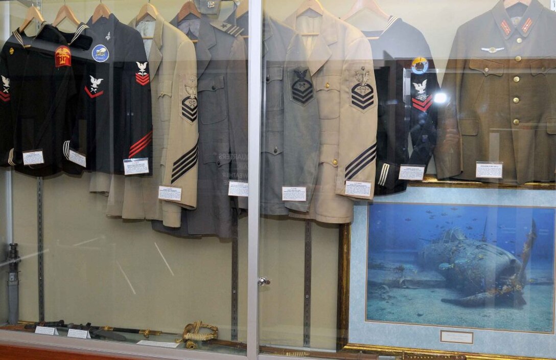 The Center for Surface Combat Systems and AEGIS Training and Readiness Center, co-located aboard Naval Support Facility Dahlgren, kick off their commemoration of the 73rd anniversary of the Battle of Midway by exhibiting World War II artifacts, including items directly related to the June 4-7, 1942 battle that changed the course of the war in the Pacific. This is the third year that Udo Goff – a defense contractor and retired Navy commander - displayed his personal collection at Dahlgren in commemoration of the Battle of Midway. Exhibit items include: U.S. Navy officer swords, ship recognition models, an aviator flight cap and radio headset, various uniforms, and the battle flag of the USS Ray (SS-271). Japanese artifacts on display include a Samurai sword, a Japanese naval officer’s dagger, and military helmets. Goff also displayed artifacts in commemoration of the Normandy D-Day invasion at a Naval Surface Warfare Center Dahlgren Division building. 
