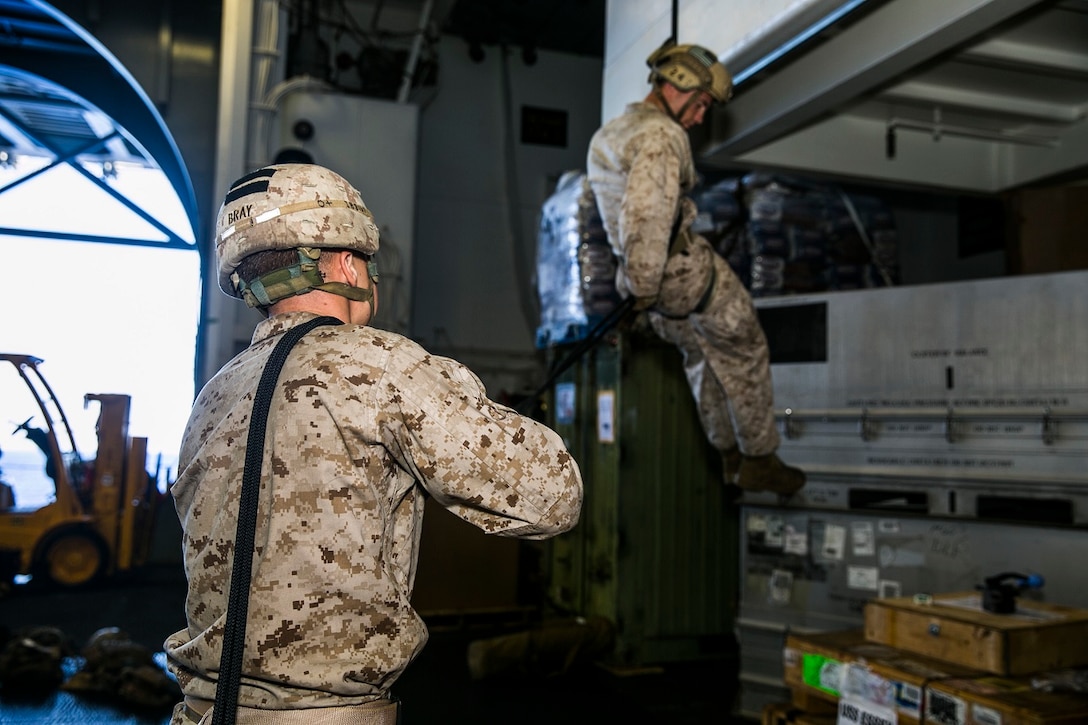 U.S. Marines with the 15th Marine Expeditionary Unit’s Maritime Raid Force rappel in the hangar bay of the USS Essex (LHD 2) in the East China Sea, June 2, 2015. Rappelling allows the Marines to lower themselves from any structure or vertical surface, allowing them to operate in any terrain. (U.S. Marine Corps photo by Cpl. Anna Albrecht/Released)