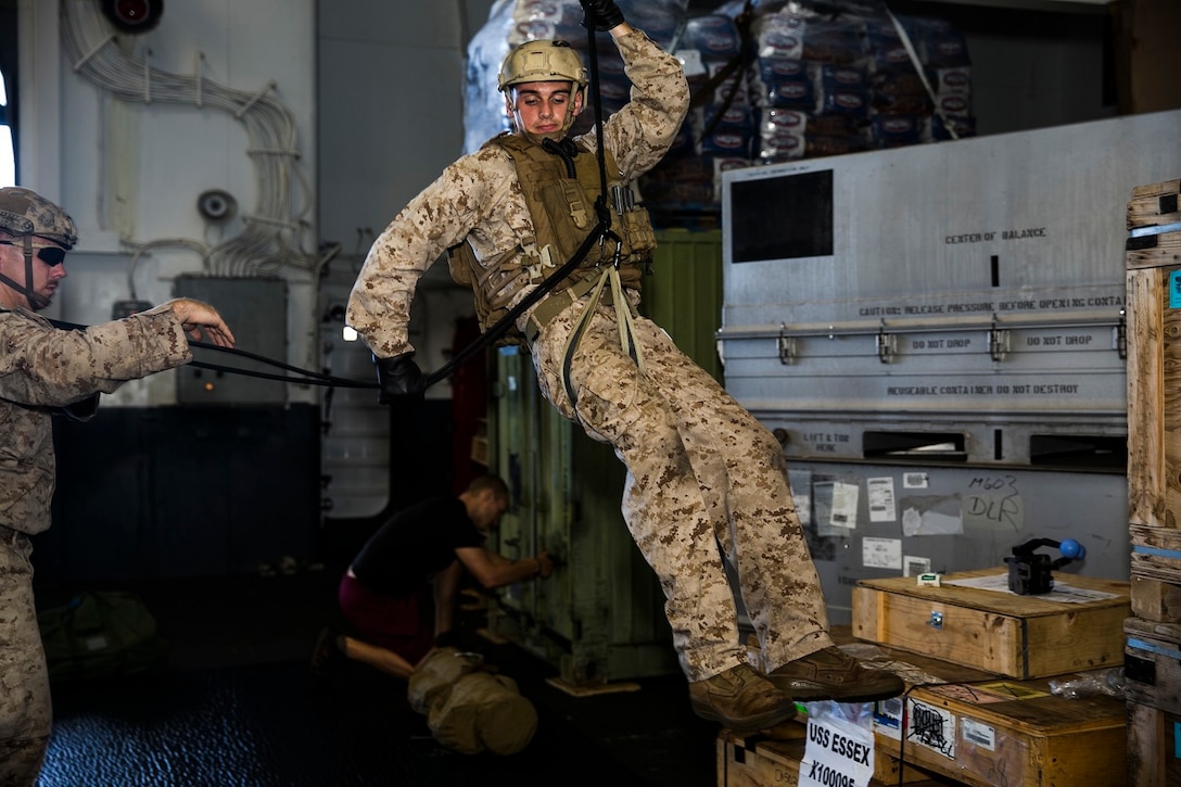 U.S. Marine Cpl. Matthew Jensen rappels in the hangar bay of the USS Essex (LHD 2) in the East China Sea, June 2, 2015. Jensen is a member of the 15th Marine Expeditionary Unit’s Maritime Force. The Maritime Raid Force Marines also worked with Marines from Lima Company, Battalion Landing Team 3rd Battalion, 1st Marine Regiment on different lowering procedures in case they need to lower gear or a casualty. (U.S. Marine Corps photo by Cpl. Anna Albrecht/Released)