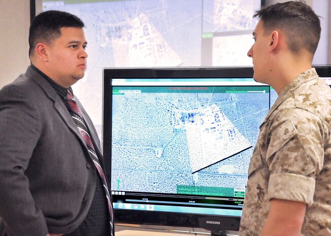 George Moreno Pineda speaks to a Marine about Full Motion Video Optical Navigation Exploitation during a Warfighter Workshop April 30 at Marine Corps Base Camp Pendleton, California. Moreno Pineda will receive the 2014 Assistant Secretary of the Navy for Research, Development and Acquisition Dr. Delores M. Etter Top Scientists and Engineers Award for his achievements as lead engineer for FMV-ONE at Marine Corps Systems Command.  