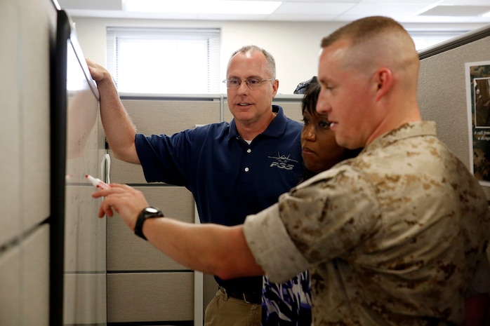 Francis Bonner (left) talks to members of his team about modifications to the Common Aviation Command and Control System, or CAC2S, in his office on Marine Corps Base Quantico, Virginia. Bonner will receive the 2014 Assistant Secretary of the Navy for Research, Development and Acquisition Dr. Delores M. Etter Top Scientists and Engineers Award for his achievements as lead engineer for the CAC2S program at Program Executive Officer Land Systems. 