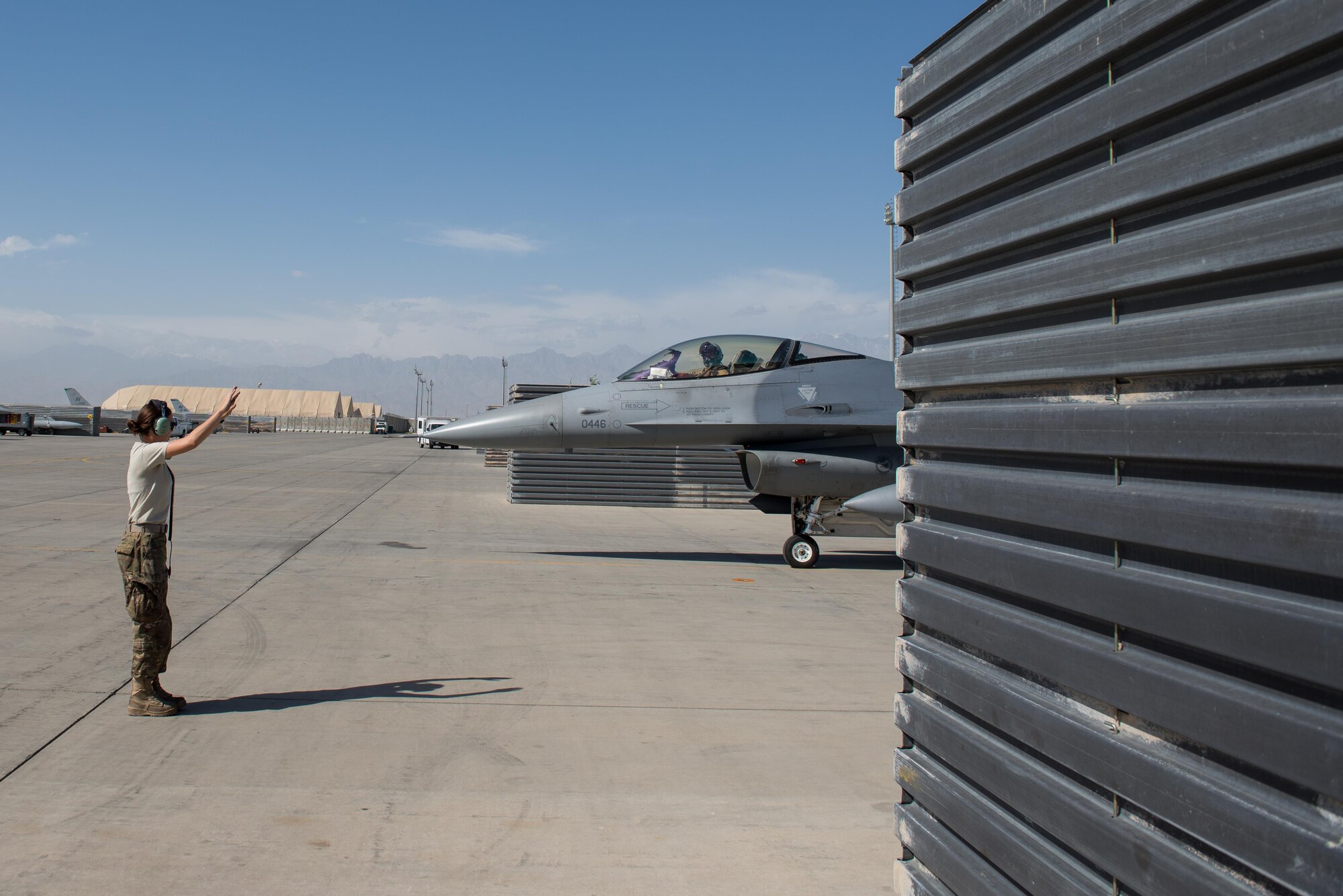 A U.S. Airman assigned to the 455th Expeditionary Aircraft Maintenance Squadron marshals an F-16 Fighting Falcon aircraft before it flies a combat sortie at Bagram Airfield, Afghanistan, June 8, 2015. The 455th EAMXS ensure Fighting Falcons on Bagram are prepared for flight and return them to a mission-ready state once they land.  (U.S. Air Force photo by Tech. Sgt. Joseph Swafford/Released)