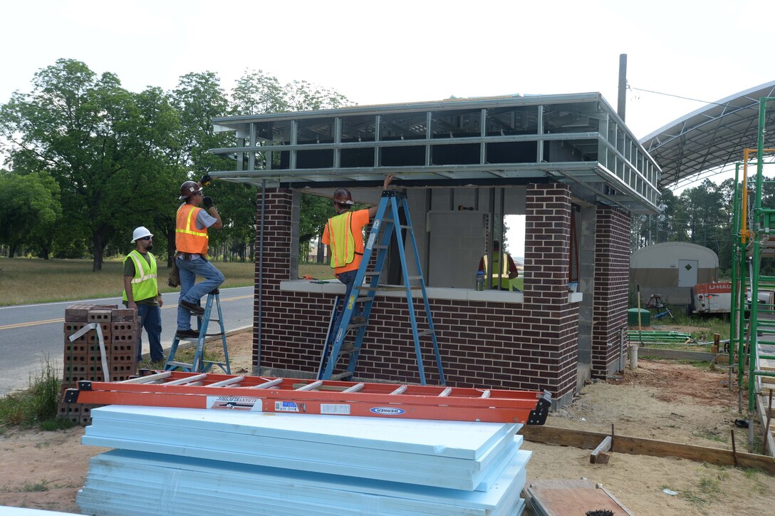 Contract workers from S & S Concrete and Construction Company, Albany, Georgia, measure the overhang of a building they are constructing on Wilkinson Way at Marine Corps Logistics Base Albany. The structure is located at the Mock Road entrance to the base and will serve as the sentry checkpoint and commercial vehicle entrance once the project is completed. The target date for initiating the rerouting of truck traffic from the Fleming Road gate to the Mock Road gate is October 1, 2015.