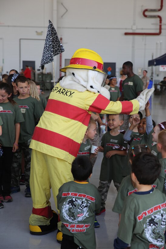 Children of service members meet Sparky, the Aircraft Rescue and Fire Fighting’s mascot, at Marine Aircraft Group 16's Junior Jarhead Day aboard Marine Corps Air Station Miramar, Calif., June 6. The children learned about fire trucks and how to use a fire fighting hose. (U.S. Marine Corps photo by Lance Cpl. Kimberlyn D. Adams/Released)