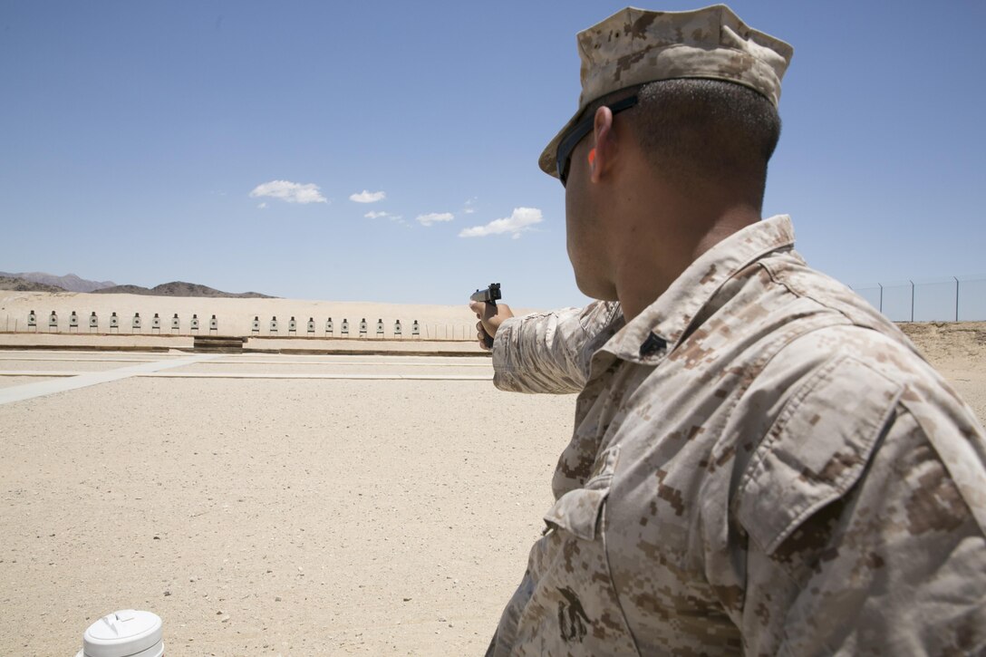 Cpl. Nathaniel Jones, shooter, Marine Corps Air Ground Combat Center Shooting Team, finishes firing an M1911 pistol during the D-Day Match sponsored by the High Desert Competitive Shooting Club at the Combat Center Rifle Range, June 6, 2015. The Excellence in Competition Pistol Match consisted of firing from the 50 yard line and the 25 yard line. (Official Marine Corps photo by Lance Cpl. Thomas Mudd/ Released)