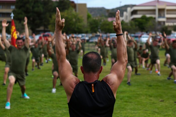 Juan Urquiaga, a trainer with Tony Horton, the creator of the fitness program P90X, demonstrates an exercise for Marines assigned to 3rd Battalion, 5th Marine Regiment, aboard Camp Pendleton, Calif., June 9, 2015. Horton believes Marines need to focus on nutrition and a wide variety of exercises to be ready for any mission as may be directed.