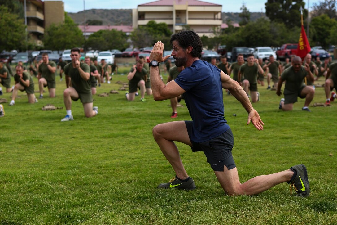 Bobby Stevenson, a trainer with Tony Horton, the creator of the fitness program P90X, demonstrates an exercise for Marines assigned to 3rd Battalion, 5th Marine Regiment, aboard Camp Pendleton, Calif., June 9, 2015. Horton believes Marines need to focus on nutrition and a wide variety of exercises to be ready for any mission as may be directed.