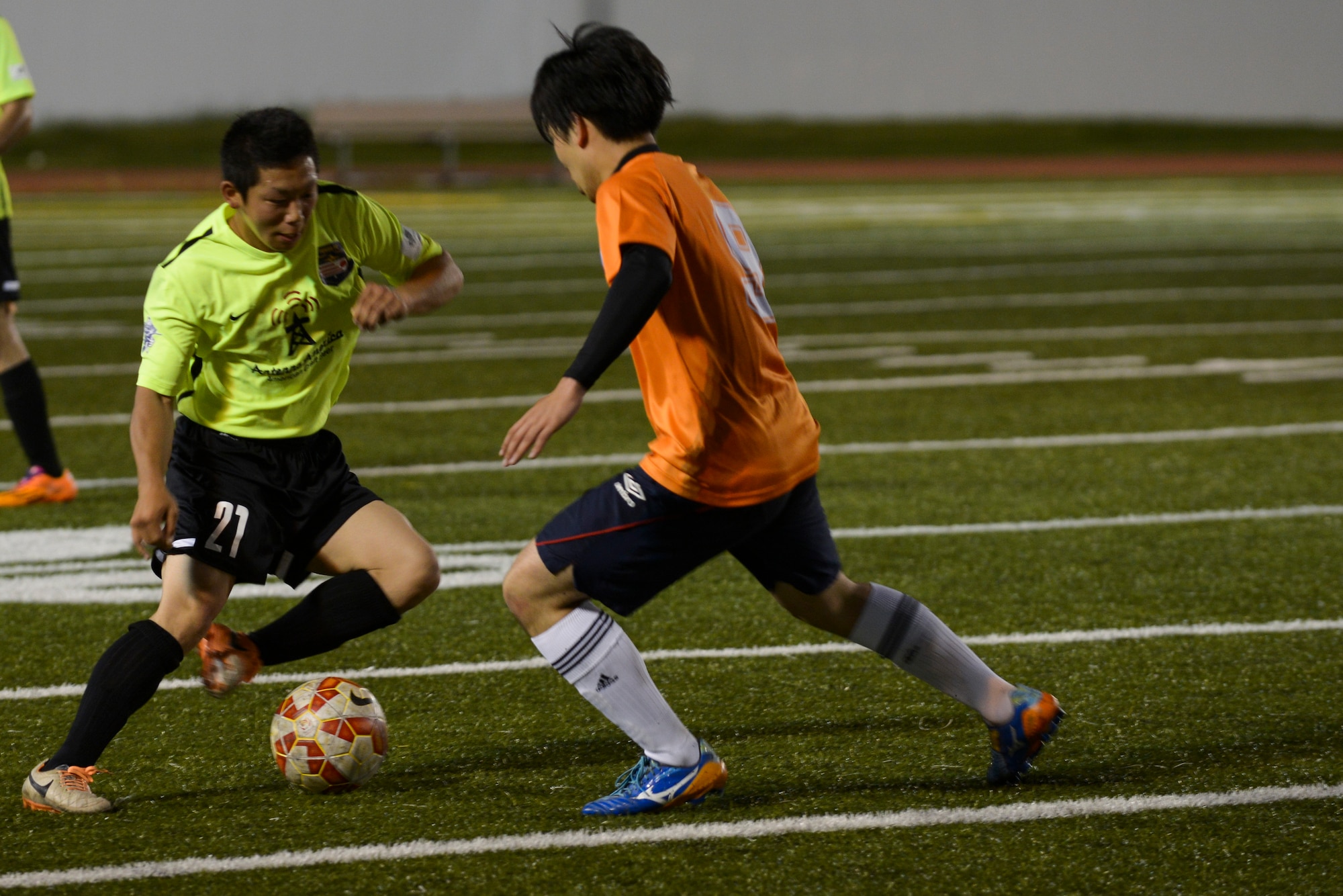 Ryo Oike, FUSSA Football Club player, makes a move past a Musketeers Football Club defender during the first half of a soccer game June 7, 2015, at Yokota Air Base, Japan. The game was tied 1-1 at half time, with the FUSSA FC going on to lose 4-2. (U.S. Air Force photo by Senior Airman David Owsianka/Released)