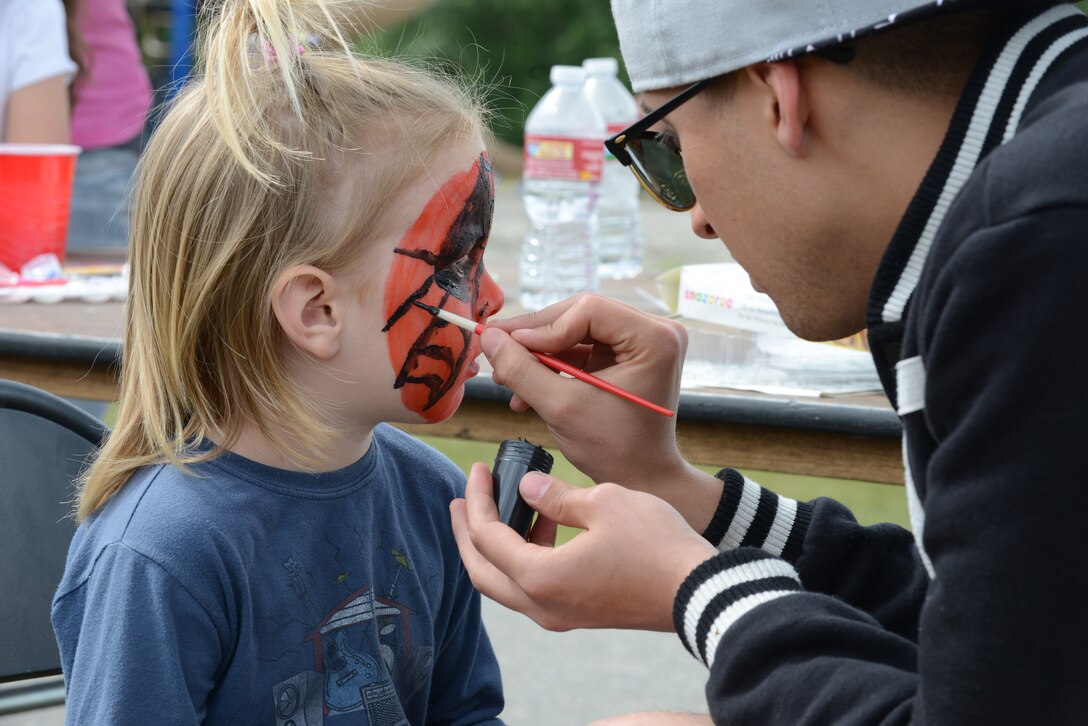 Miles Sefton gets his face painted like Spiderman during the 354th Mission Support Group Summer Bash June 5, 2015, at the Chena Lake Recreation Area in North Pole, Alaska. Snow cones, face painting and water balloon fights were a few of the activities made available for children at the event. (U.S. Air Force photo by Senior Airman Ashley Nicole Taylor/Released)