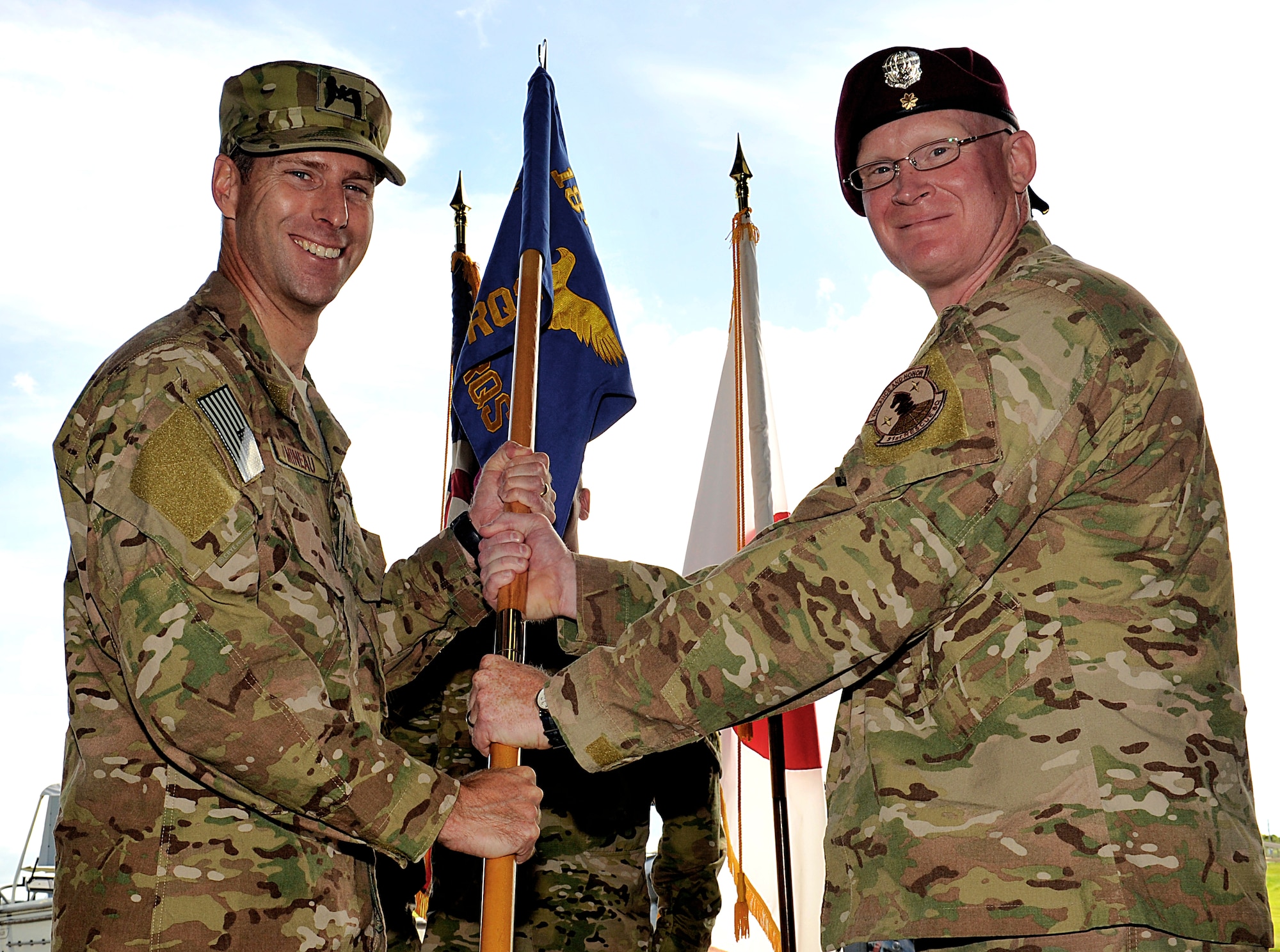U.S. Air Force Col. David Mineau, 18th Operations Group commander, passes the 31st Rescue Squadron guidon to Maj. Matthew McGuinness, 31st RQS commander, during the 31st RQS change of command ceremony on Kadena Air Base, Japan, June 10, 2015. McGuinness is a senior non-rated aircrew member with more than 900 flight hours in the HH-60G Pave Hawk, CH-53 Sea Stallion, MH-53 Pave Low, CH-47 Chinook and HC-130 Hercules. (U.S. Air Force photo by Naoto Anazawa)