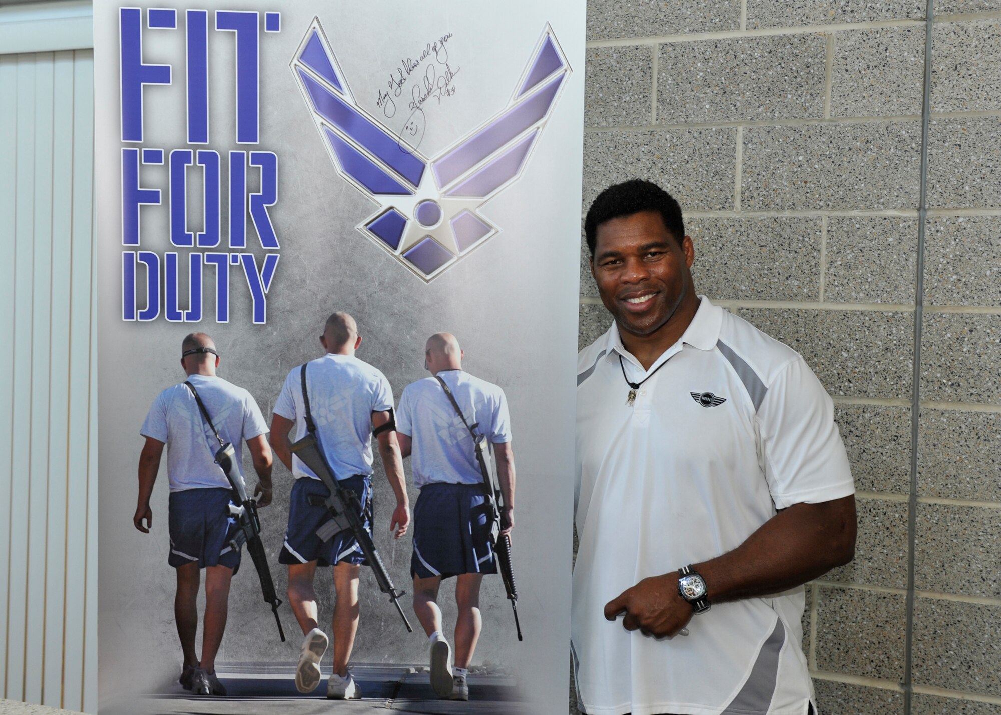Herschel Walker, Professional athlete and business owner, stands next to a poster he signed for the base Fitness Center June 5. Walker signed autographs and met Airmen and their families during his visit to Tyndall. (U.S. Air Force photo by Airman 1st Class Sergio A. Gamboa)  
