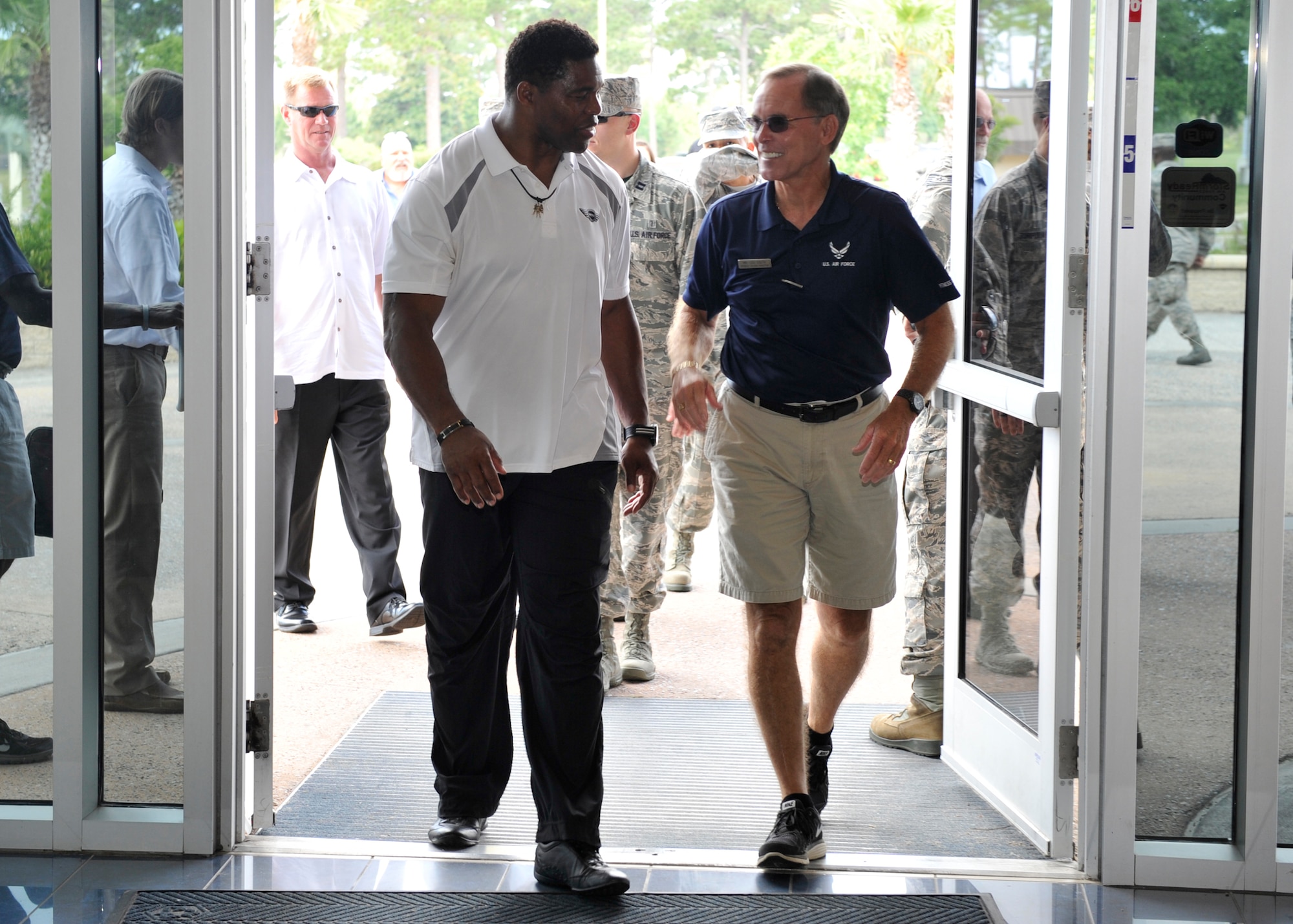Herschel Walker, professional athlete and business owner, walks with Lou South, 325th Force Support Squadron Fitness Center director, June 5. Walker came to Tyndall to talk to Airmen about mental health during the Comprehensive Airman Fitness Day. (U.S. Air Force photo by Airman 1st Class Sergio A. Gamboa)  