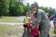 U.S. Air Force Airman 1st Class Brooke Hunt, from the New Jersey Air National Guard's 177th Fighter Wing Fire Department, helps a student use a fire hose on June 9, 2015 at Alder Avenue Middle School's Not All Heroes Wear Capes event in Egg Harbor Township, N.J. Local first responders and military personnel gathered at the school to provide a hands-on educational experience for students, teaching them about the services they provide to the local community. (U.S. Air National Guard photo by Airman 1st Class Amber Powell/Released)