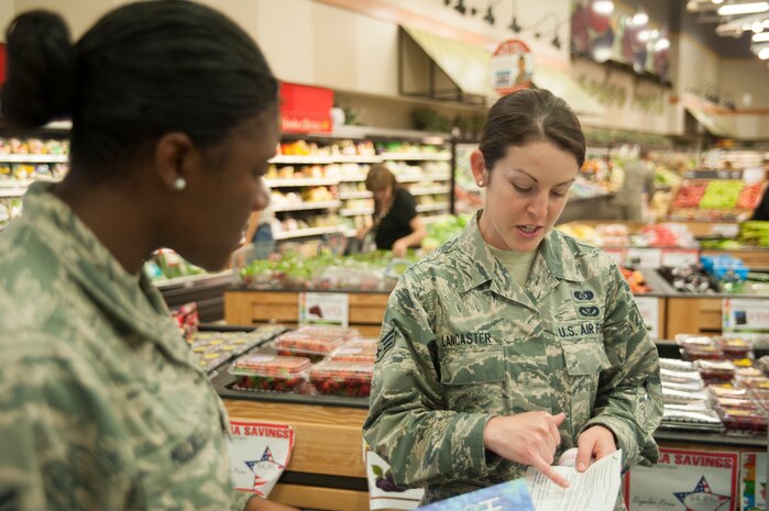 Senior Airman Anna Lancaster, 628 Civil Engineer Squadron emergency manager, goes over hurricane information  with a customer at the Joint Base Charleston – Air Base Commissary June 5, 2015with a commissary customer June 5, 2015. Throughout the week, 628th CES emergency management personnel visited various locations across the installation to inform the base populous about hurricane season, which started in June 1 and runs through November. (U.S. Air Force photo/Staff Sgt. William O'Brien)