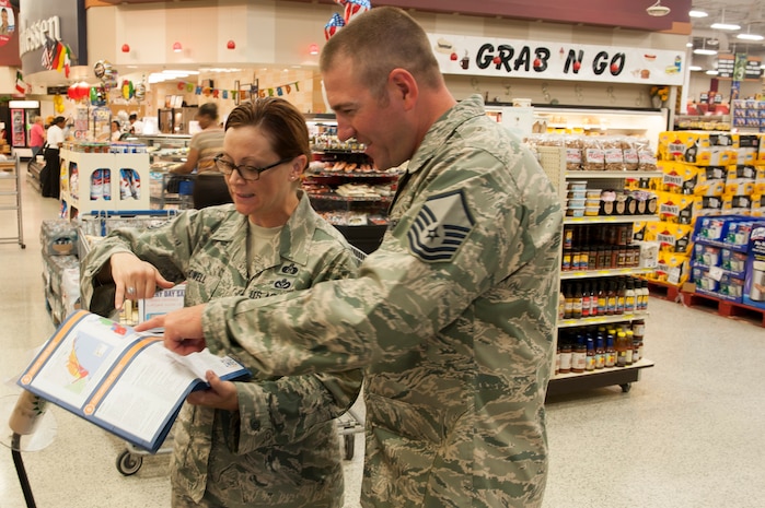 Master Sgt. Heather Howell, 628 Civil Engineer Squadron, NCO in charge of emergency management, goes over hurricane information with a commissary customer at the Joint Base Charleston – Air Base Commissary  June 5, 2015. Throughout the week, 628th CES emergency management personnel visited various locations across the installation to inform the base populous about hurricane season, which started in June 1 and runs through November. (U.S. Air Force photo/Staff Sgt. William O'Brien)