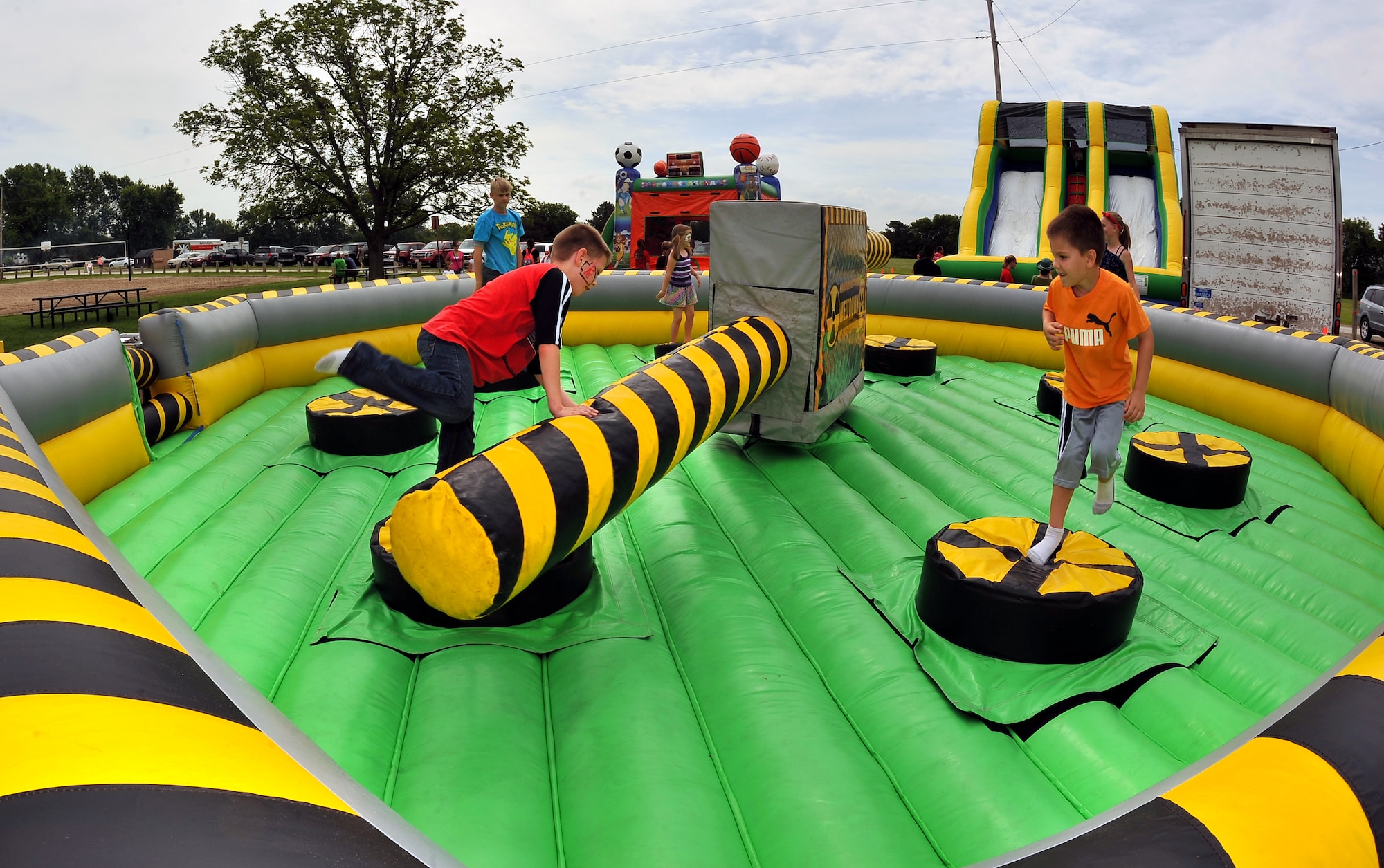 Kids jump and duck under the rotating arms of one of several inflatable activities spread throughout the Offutt Appreciation Day Picnic.  The picnic has been hosted by the Offutt Advisory Council for more than twenty years.  (U.S. Air Force photo by Josh Plueger)