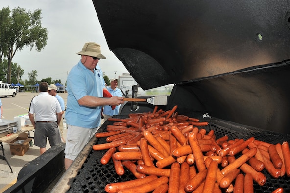Mr. Rusty Hike, a Bellevue resident and long-time Offutt Advisory Council volunteer, cooks a mountain of hot dogs at the annual Offutt Appreciation Day Picnic.  The OAC has been hosting the picnic for members of Offutt Air Force Base, Nebraska, for more than two decades.  (U.S. Air Force photo by Josh Plueger)