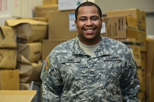 U.S. Army Pfc. Michael King, McDonald Army Health Center Medical Material logistics technician, poses for a photo at Fort Eustis, Va., June 8, 2015. King and members from his unit took part in a run to help celebrate the Army Birthday, but the birthday was not the only reason he was motivated to run.  King’s son is his everyday motivation. (U.S. Air Force photo by Senior Airman Kimberly Nagle/Released) 