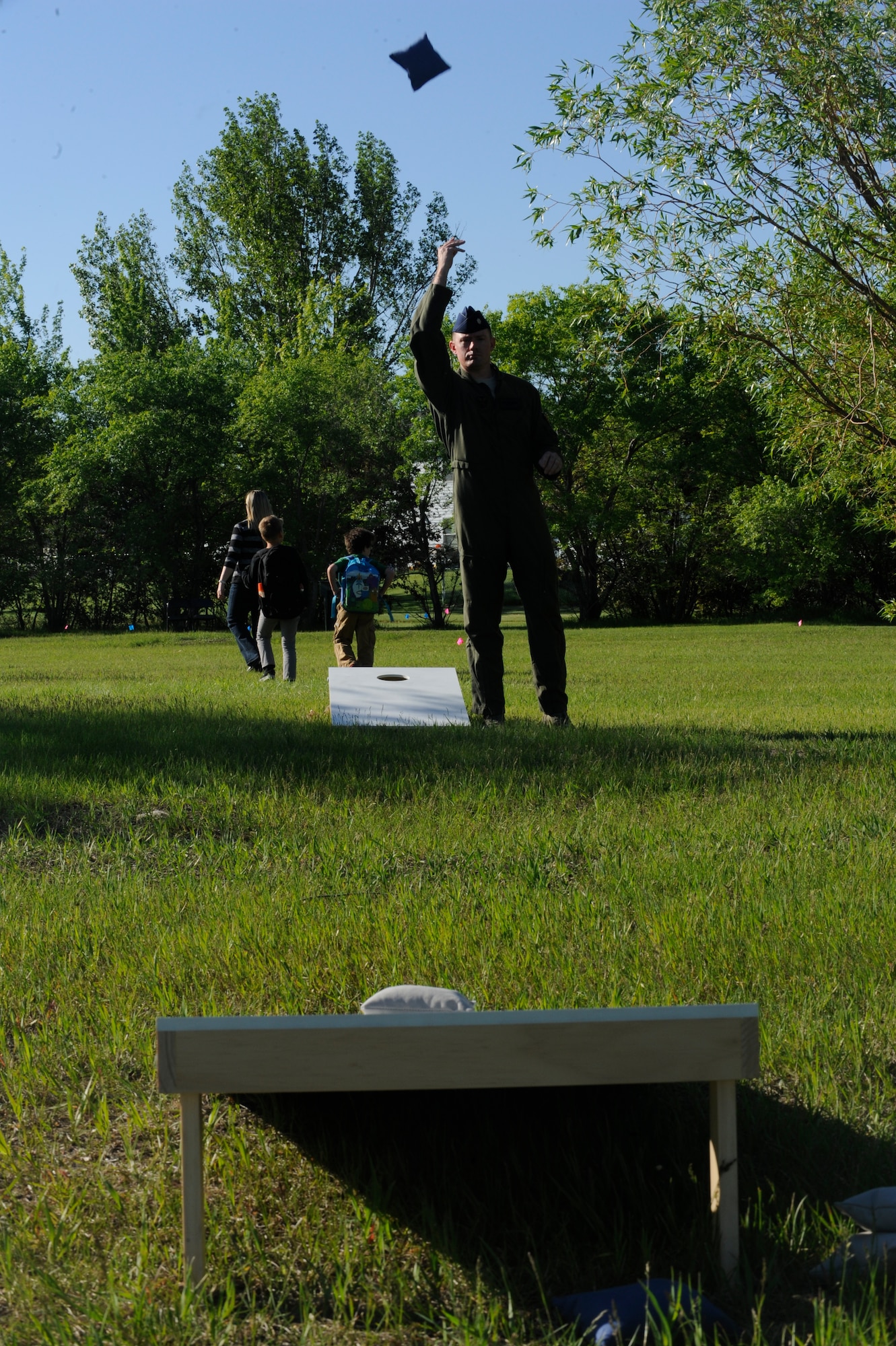 Lt. Col. Josh Hampton, 54th Helicopter Squadron director of operations, throws a bean bag during a game of “corn hole” at the Balfour Beatty notebook burn at Minot Air Force Base, N.D., June 3, 2015. In addition to games the event featured areas to make s ‘mores, a bouncy castle, free food and drinks and demonstrations by the fire department. (U.S. Air Force photo/Senior Airman Stephanie Morris)
