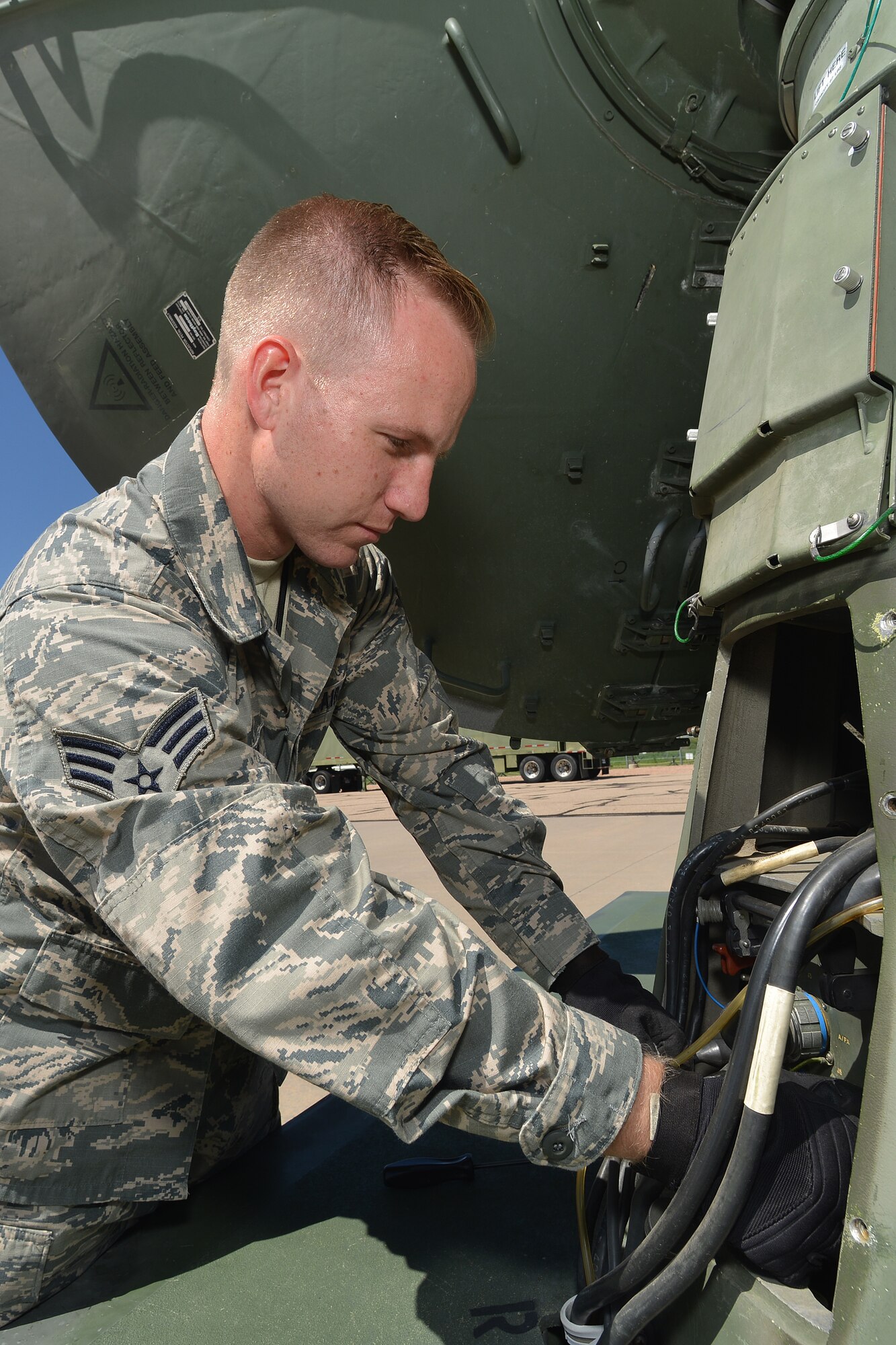 U.S. Air Force Senior Airman Jonathan R. Smail, a transmission technician from the 233rd Space Communications Squadron, Colorado Air National Guard, checks the cables hooked up to a mobile satellite trailer at Greeley Air National Guard Station, Greeley, Colo., June 7, 2015. Smail, who troubleshoots and maintains satellite communications electronic equipment for the 233rd's one-of-a-kind mobile nuclear and missile launch tracking mission, won the 2014 Air National Guardsman of the year. (Air National Guard photo by Tech. Sgt. Wolfram M. Stumpf)