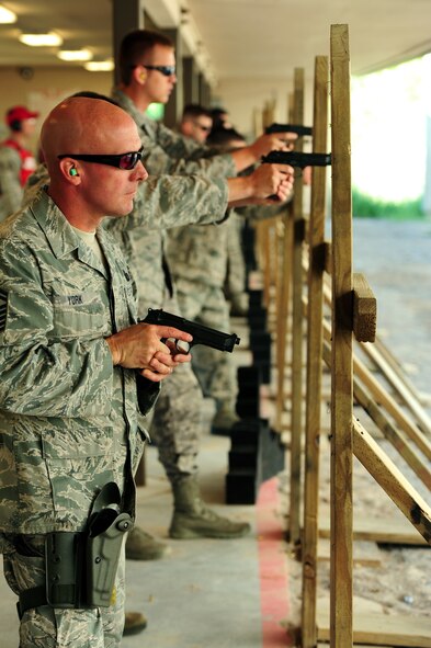 U.S. Air Force Senior Master Sgt. Rob York, member of Security Forces at the 180th Fighter Wing in Swanton, Ohio, readies himself to qualify with the standard issue M9 handgun at the Alpena Combat Readiness Training Center small arms firing range in Alpena, Michigan on June 9, 2015. Guardsmen of the 180th FW set aside approximately two weeks out of every summer to complete their annual training, during which they re-qualify with firearms and maintain combat readiness skills. U.S. Air Force Staff Sgt. Jasen Jazwiecki, Combat Arms Training and Maintenance instructor at the 180th Fighter Wing in Swanton, Ohio, provides feedback to Security Forces Airmen from the 180th FW on sighting in their rifles before the qualification round at the Alpena Combat Readiness Training Center small arms firing range in Alpena, MI on June 9, 2015. 180th CATM Instructors oversee the qualification sessions, ensure safety at the range, and instruct Airman on how to improve their skills. (Air National Guard photo by Tech. Sgt. Nic Kuetemeyer/Released)