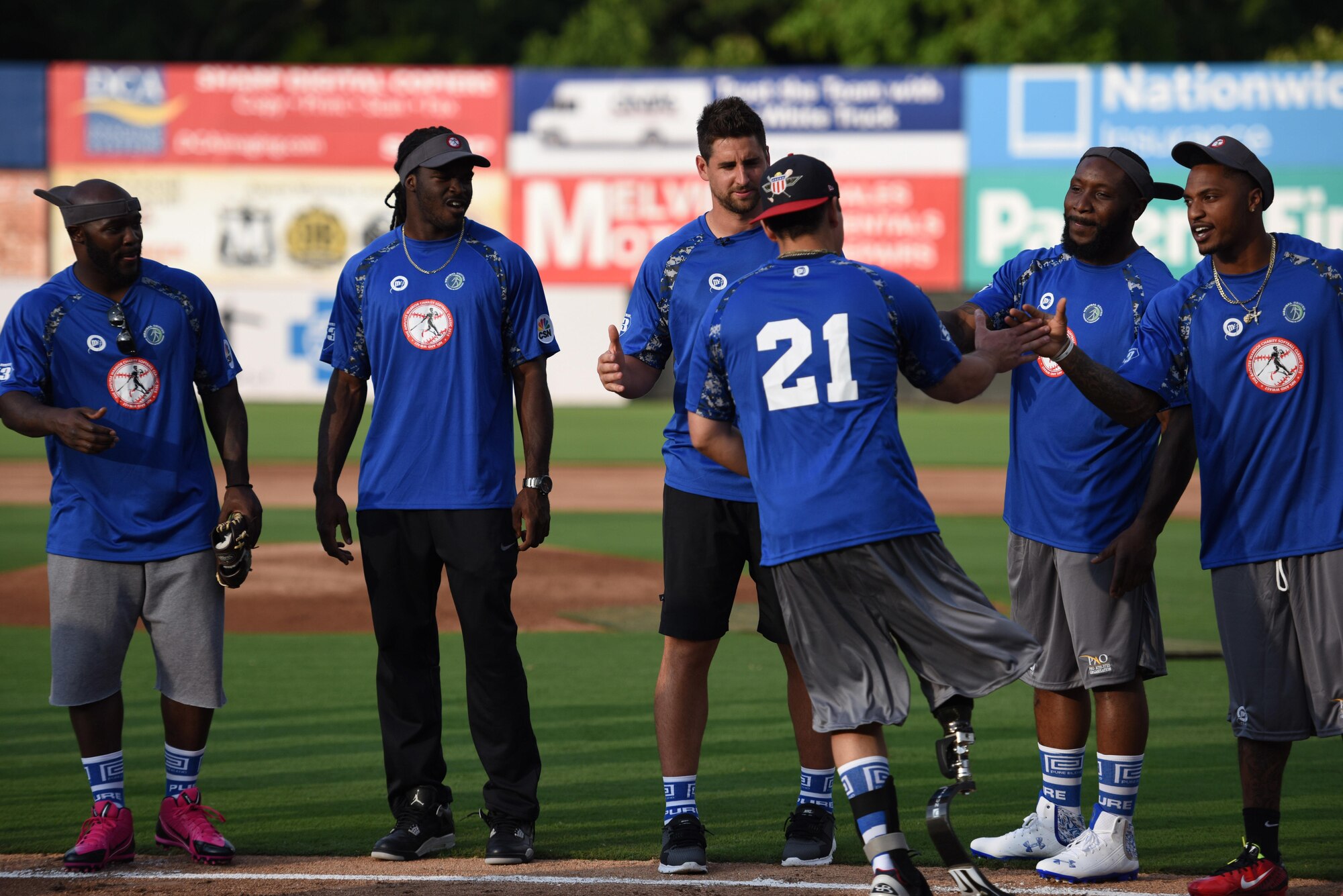 Mike Dreyer, a member of the Wounded Warrior Amputee Softball Team and representing the Air Force, shakes hands with his team members during team introductions at the 3rd annual Amputee Warrior Softball Classic on June 6, 2015, at Prince George's Stadium in Bowie, Md. (U.S. Air Force Photo/Staff Sgt. Carlin Leslie)