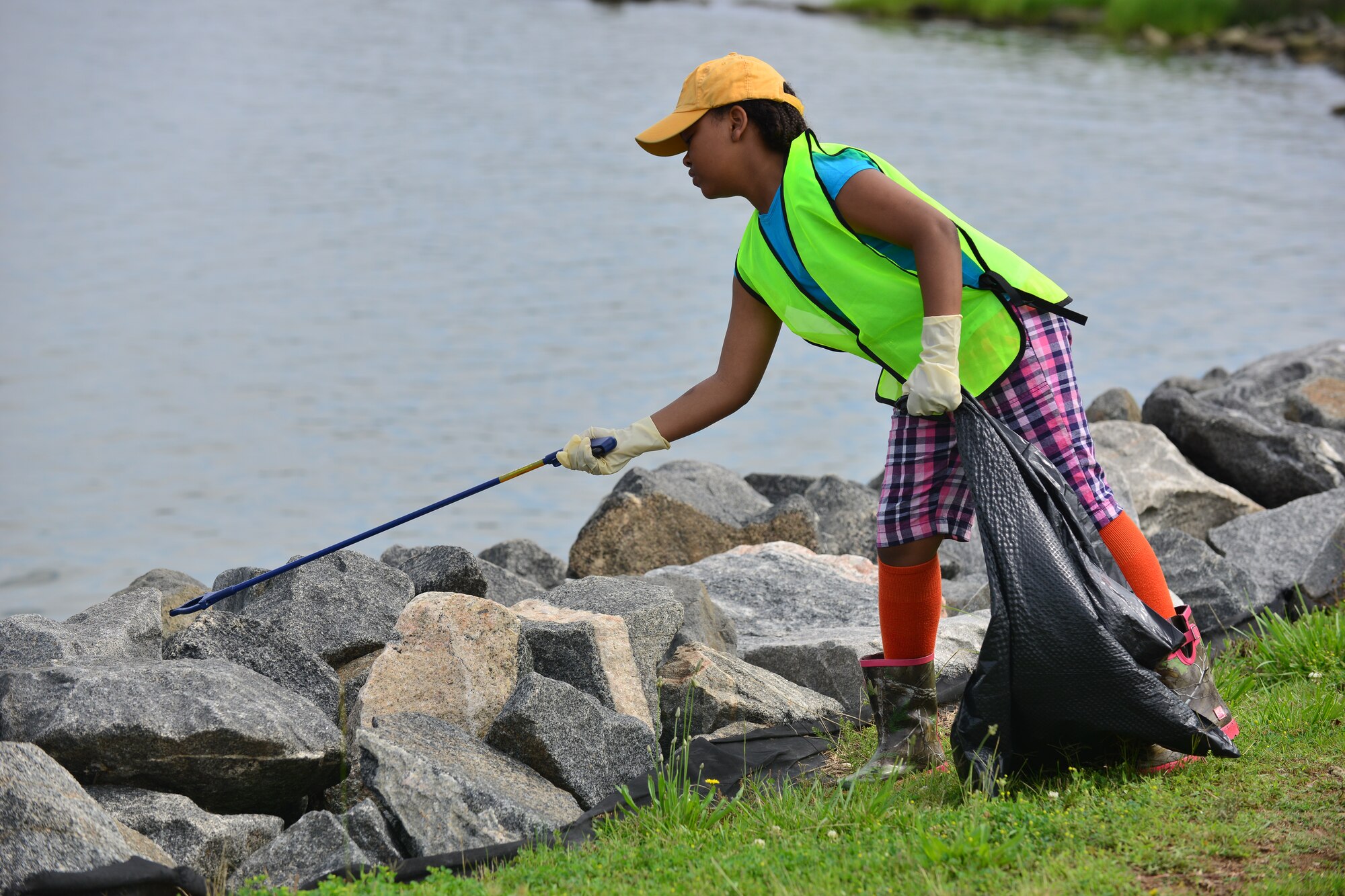 Jourdan Griffin, daughter of U.S. Army Capt. Wayne Griffin, Bravo Company, 1st Battalion, 210th Aviation Regiment commander, cleans the Fort Eustis, Va., shoreline June 6, 2015. Jourdan was one of the approximately 6,000 volunteers who added to removing about 125,000 pounds of harmful debris throughout Virginia’s shorelines.  (U.S. Air Force photo by Staff Sgt. Natasha Stannard/Released)