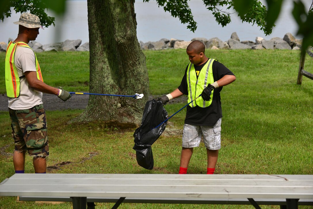 U.S. Army Capt. Wayne Griffin, Bravo Company, 1st Battalion, 210th Aviation Regiment commander, and his son, Wayne III, pick up trash during Clean the Bay Day at Fort Eustis, Va., June 6, 2015. This year, participants from Fort Eustis and Langley Air Force Base collected approximately 2,750 pounds of trash and debris. (U.S. Air Force photo by Staff Sgt. Natasha Stannard/Released) 