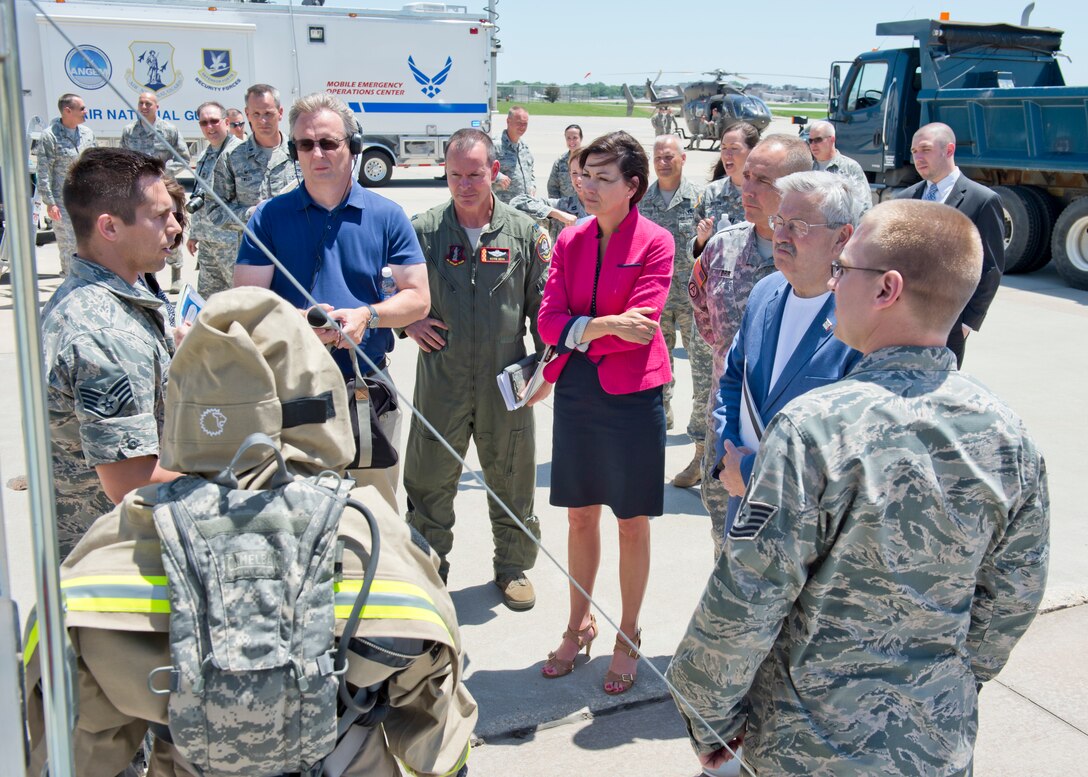 The 132nd Wing, Iowa Air National Guard based in Des Moines, Iowa hosted Iowa Governor Terry Branstad and Lieutenant Governor Kim Reynolds during a tour of the Wing’s capabilities on June 9. Maj. Gen. Timothy Orr, The Adjutant General of Iowa (center right), and 132nd Wing Commander Col. Kevin Heer (center in flight suit) also attended, as Iowa officials were briefed on the unit’s three new missions – Intelligence Surveillance Reconnaissance, Defensive Cyber Operations, and MQ-9 Remotely Piloted Aircraft flying operations. Iowa Air National Guard Staff Sgt. Jonathan Clayberg (far left) explains the capabilities of the Wing’s Fatality Search and Recovery Team.  (Iowa Air National Guard photo by Tech. Sgt. Linda K. Burger)