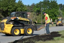 Ryan Twomey, 66th Civil Engineering Division summer hire, spreads fresh top soil along Barksdale Street on base with other CE Roads and Grounds personnel, June 10. The top soil, a product of CE's composting operation, is made from leaves, grass clippings and other fine organic material the grounds maintenance team ends up with throughout the year. The material is turned periodically during ideal weather conditions and decomposes to become the rich, black and nutrient-filled product that is spread on base for new grass to grow. CE generates between 1,500 to 2,000 yards of new top soil annually. (U.S. Air Force photo by Linda LaBonte Britt)