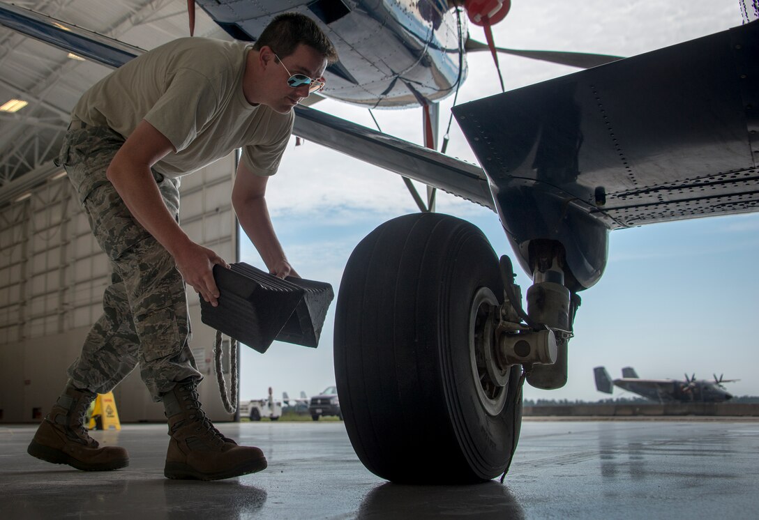 Staff Sgt. Stephen Volheim, 919th Special Operations Aircraft Maintenance Goup, removes the chocks from the C-145 June 6 at Duke Field, Fla. The 919th SOMXG is comprised of 919th SOMXS, 919th SOAMXS, 919th SOMOF, and the 592nd SOMXS.  Their primary mission is the maintenance of the C-145 aircraft. (U.S. Air Force photo/Tech. Sgt. Jasmin Taylor)
