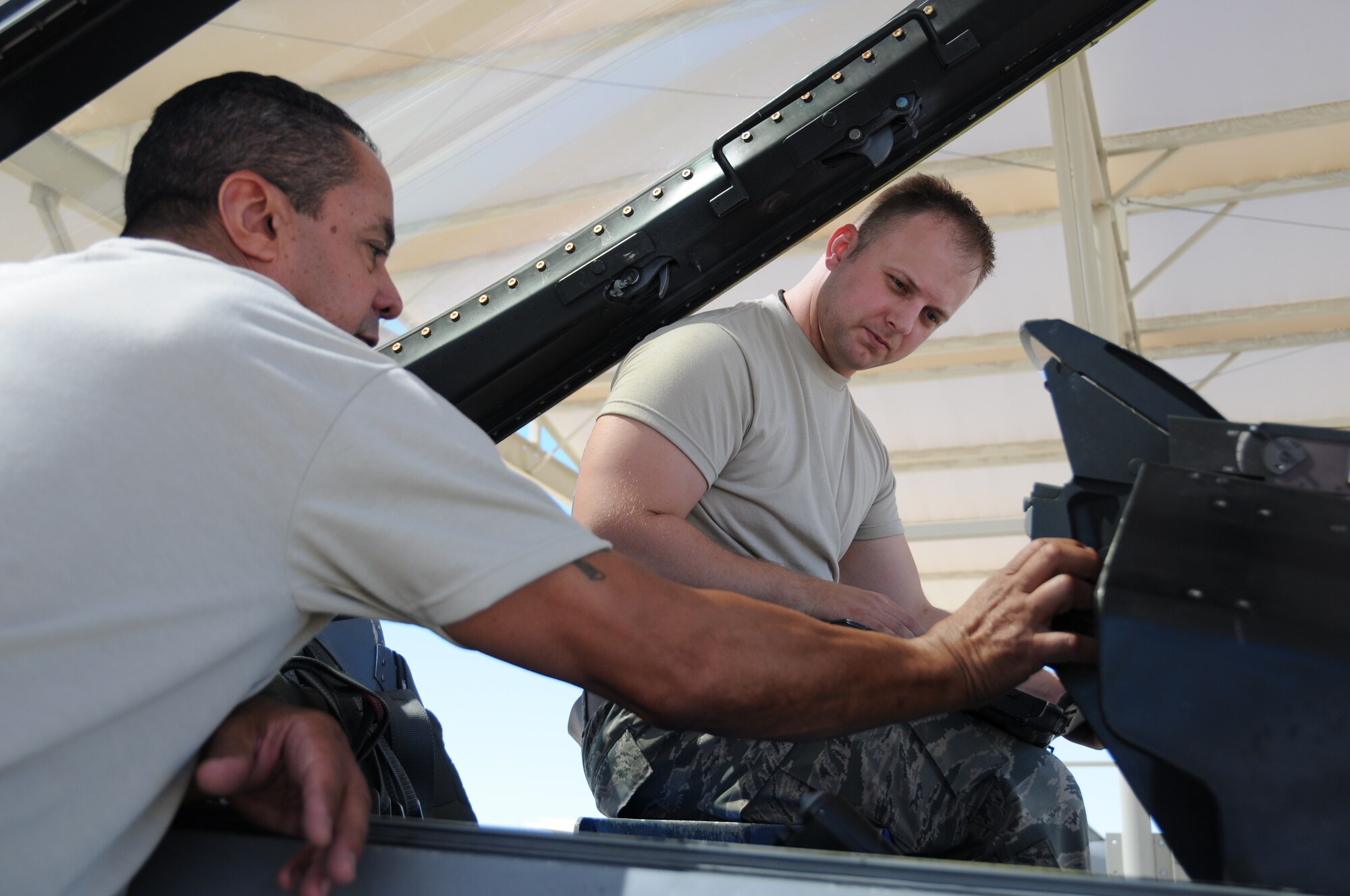 Master Sgt. Steven Joubert (left) and Senior Airman Brandon Simmons, both crew chiefs with the 944th Fighter Wing, Detachment 1, Luke Air Force Base, Ariz., perform safe for cockpit entry training on an F-16, June 7.  This is the first unit training assembly that the newly formed Det. 1 has been able to work directly on the aircraft that they will be maintaining. (U.S. Air Force photo taken by Staff Sgt. Joshua Nason)
