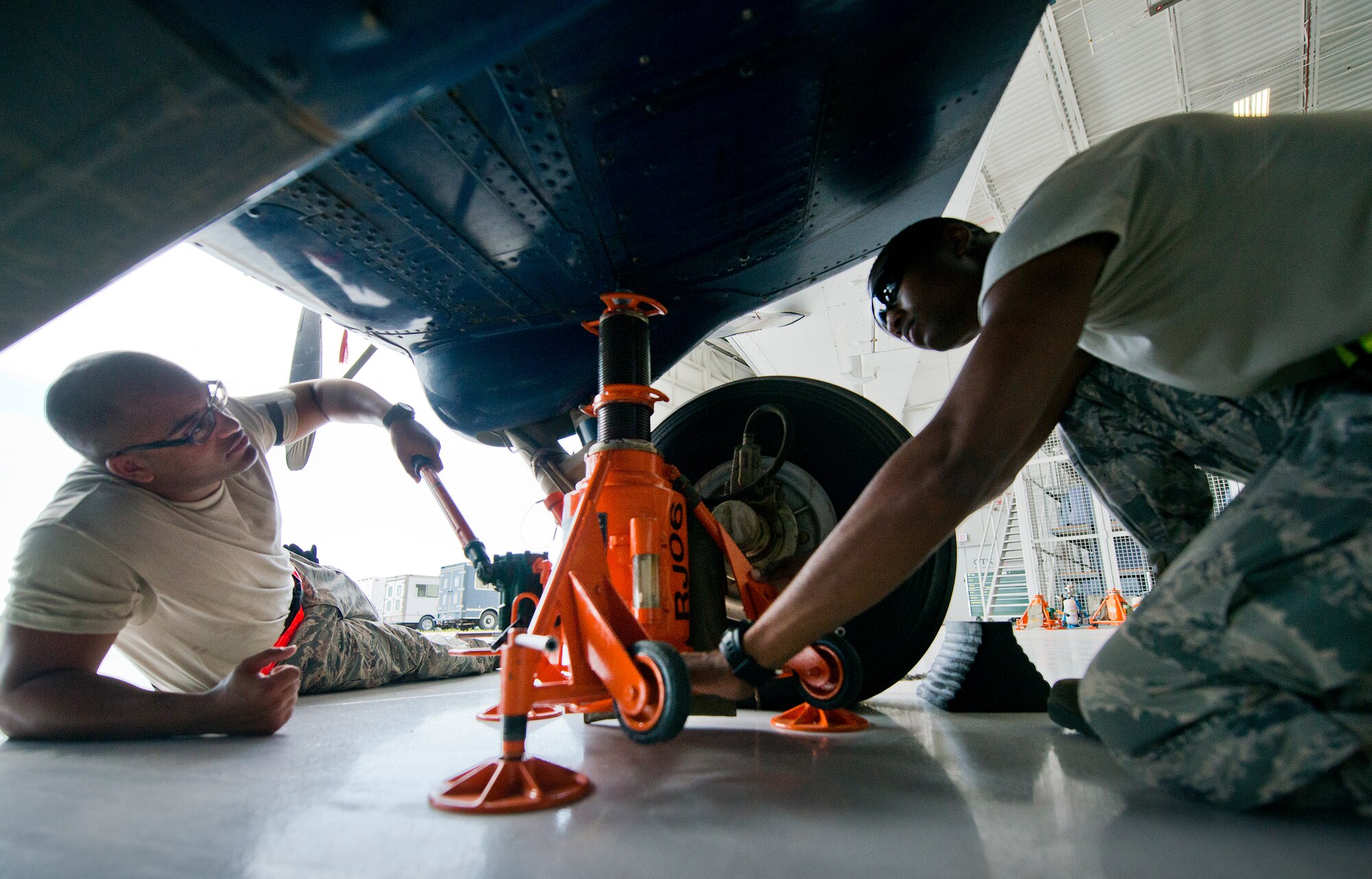 Senior Airman Kevin Cahn and Airman Mario Hill, 919th Special Operations Maintenance Group, uses the jack to lift the landing gear June 6 at Duke Field, Fla. The 919th Special Operations Maintenance Group is comprised of 919th SOMXS, 919th SOAMXS, 919th SOMOF, and the 592nd SOMXS.  Their primary mission is the maintenance of the C-145 aircraft. (U.S. Air Force photo/Tech. Sgt. Sam King)