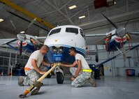 Senior Airman Kevin Kahn, and Airman Mario Hill, 919th Special Operations Maintenance Group, connect a tow bar onto a C-145 June 6 at Duke Field, Fla. The 919th SOMXG is comprised of 919th SOMXS, 919th SOAMXS, 919th SOMOF, and the 592nd SOAMXS.  Their primary mission is the maintenance of the C-145 aircraft.  (U.S. Air Force photo/Tech. Sgt. Sam King)