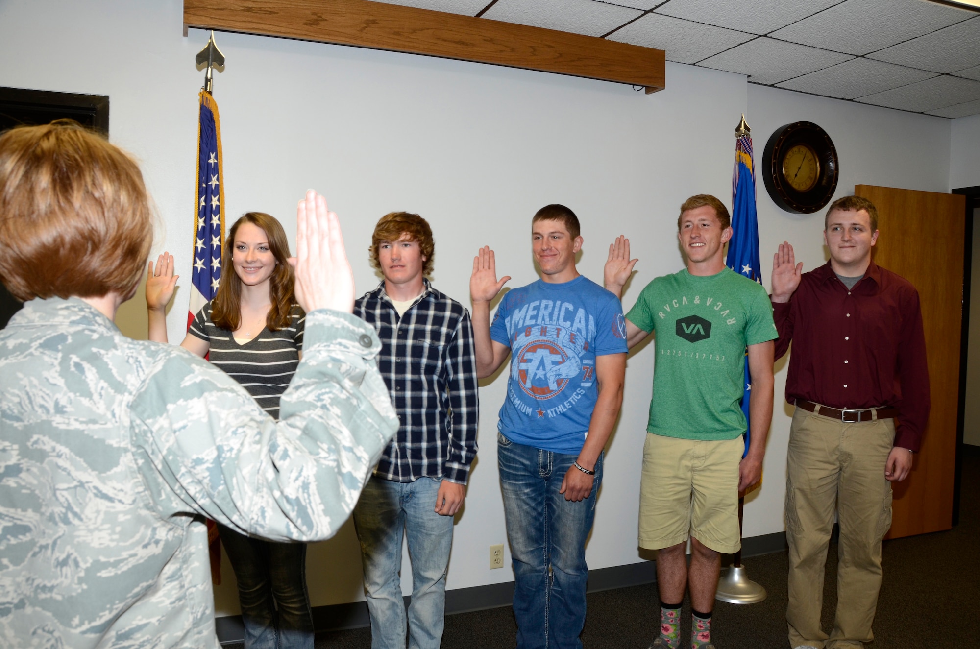 SIOUX FALLS, S.D. - Maj. Sallie Ketcham, 114th Force Support Squadron commander, leads new enlistees in reciting the oath of enlistment at Joe Foss Field, S.D. June 5, 2015.  The five members pictured left to right; Kirsten Stevens, Viborg, Parker Ramstad, Colton, Hunter Kjose, Lennox, Jacob Anderson, Hartford, and Brian King Canistota were five of the seven members enlisted on this date at the South Dakota Air National Guard. 114th Force Support Squadron personnel worked overtime to ensure these new members were enlisted before the deadline for them to receive their enlistment bonus for joining the unit.(National Guard photo by Senior Master Sgt. Nancy Ausland/Released)